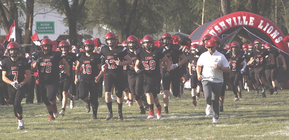 Coach Sliger runs on to the field with his team.